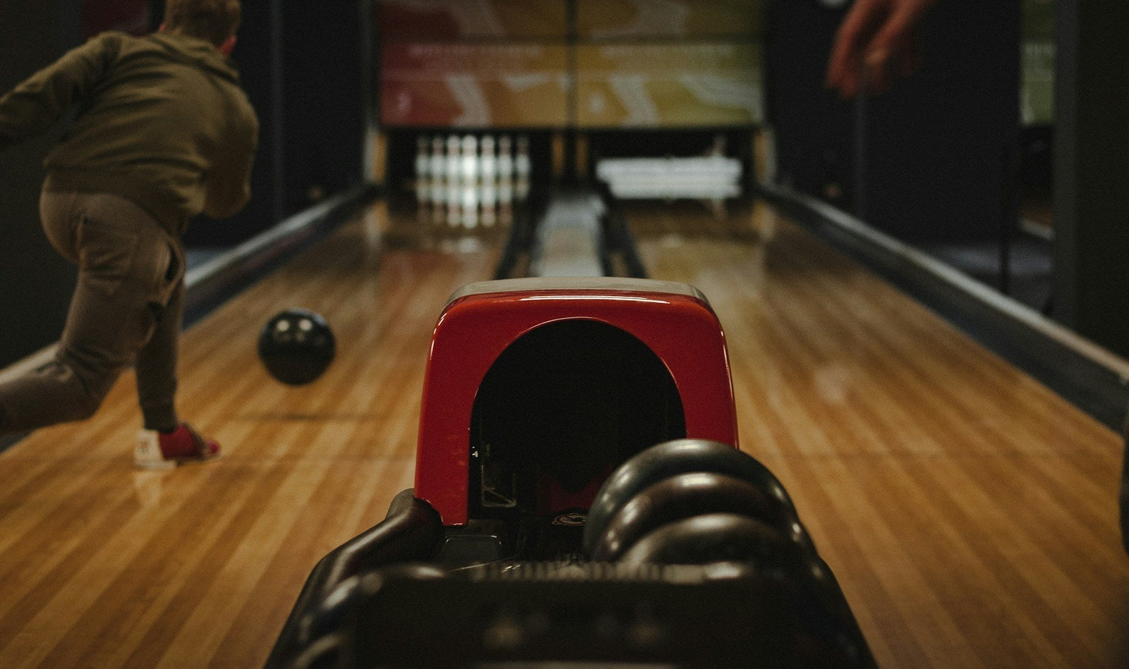 A bowler throwing a straight, and the ball is mid-motion