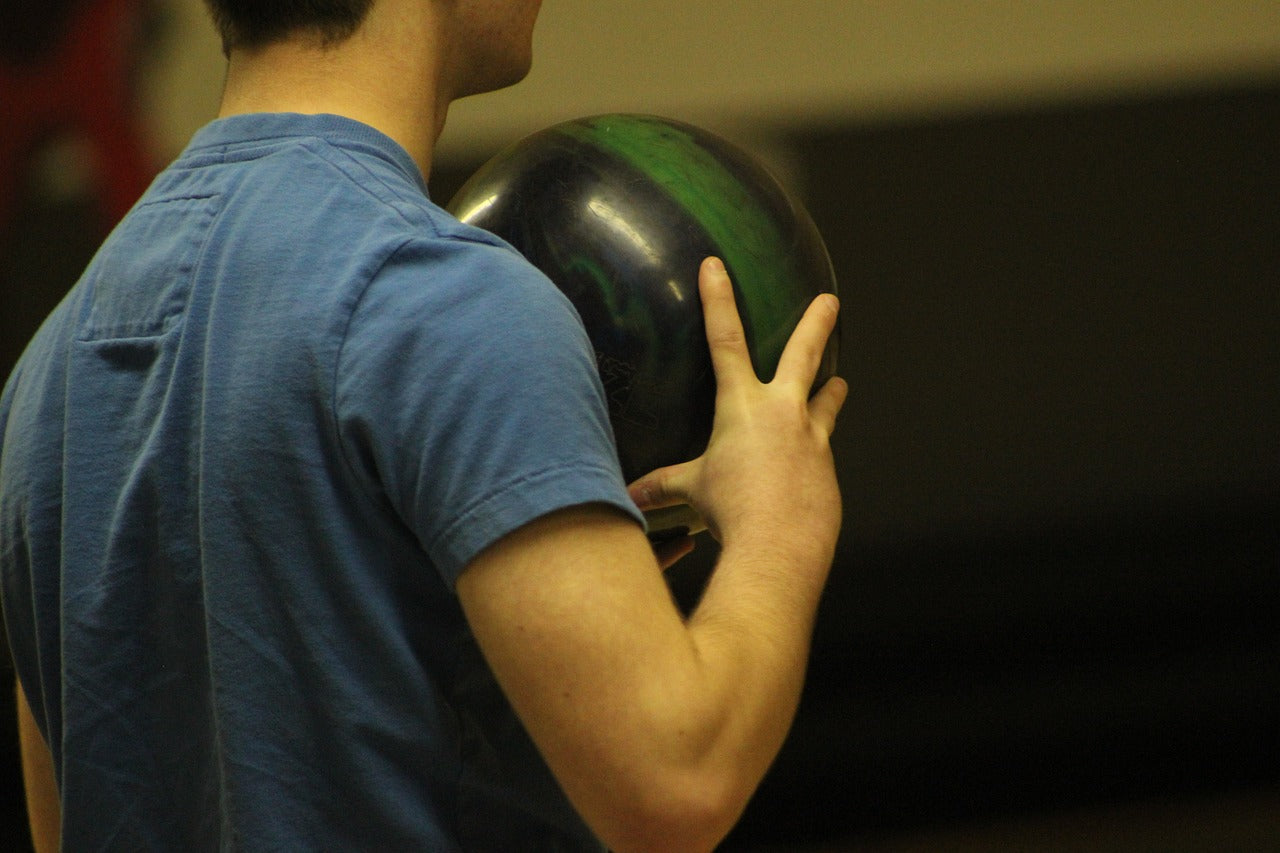 Image from behind of an individual holding a bowling ball