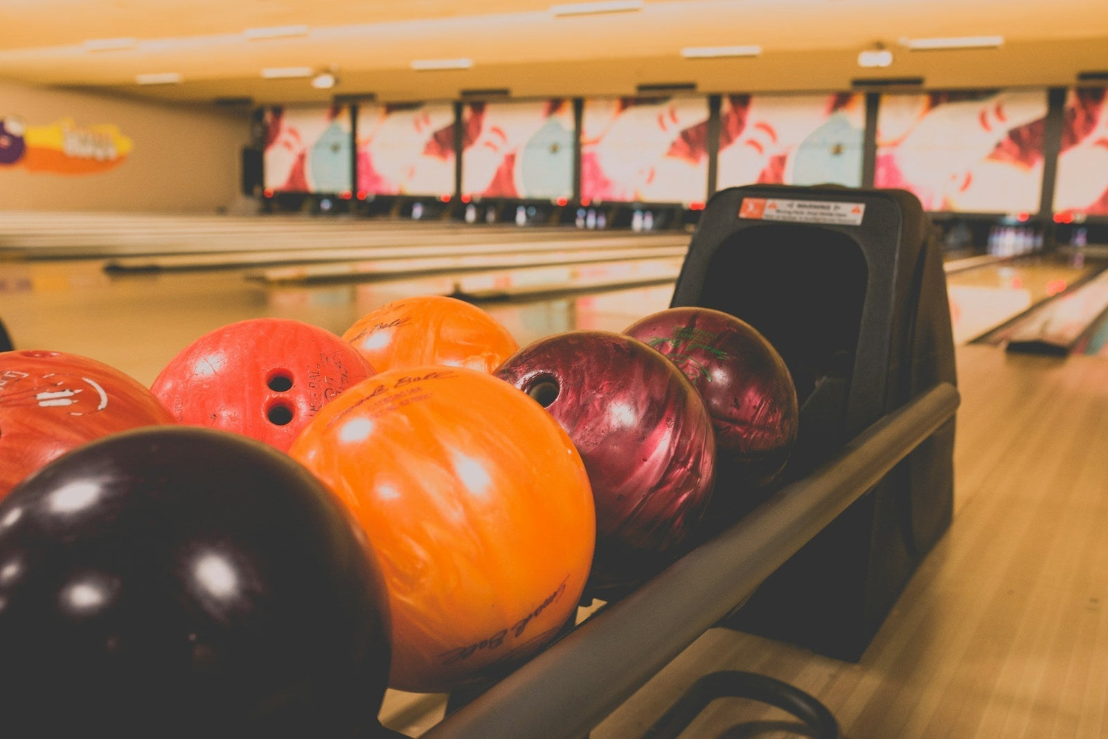 Image of bowling balls of different weights at a bowling alley