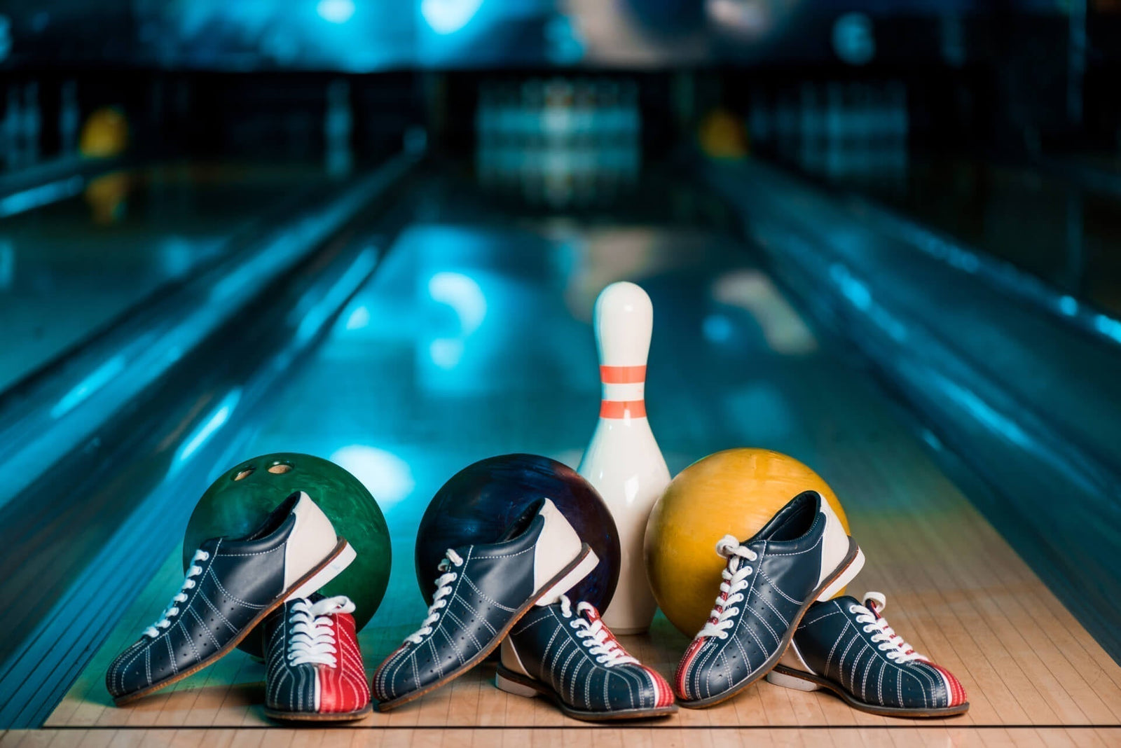 bowling shoes in front of bowling balls and a pin