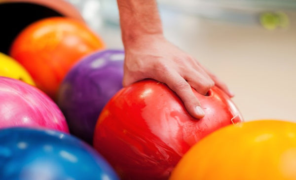 A close-up image of a hand grabbing a ball
